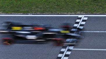 An F1 car races past the finish line